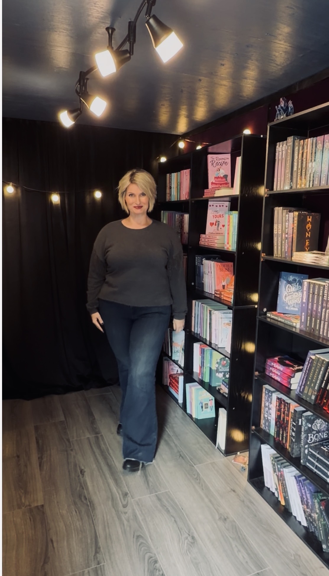 T. L. Johnson standing inside Midnight Haven Books, her mobile indie bookshop